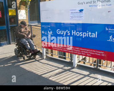 UK.Homme avec handicap en dehors de gars et de l'hôpital St.Thomas.entrée Photo par Julio Etchart Banque D'Images