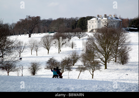 Les gens de la luge sur le terrain de golf à Beckenham Place Parc avec la maison en arrière-plan Banque D'Images