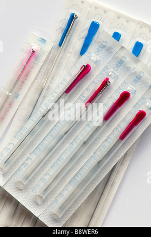 Assortiment de différentes tailles de paquets scellés dans les aiguilles d'acupuncture prises sur un fond blanc