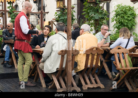 Tallinn, Estonie, Europe. Garçon de restaurant Olde Hansa en costume médiéval qui desservent des clients Banque D'Images