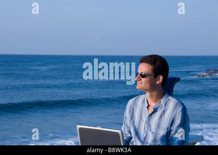 Un homme d'affaires avec un ordinateur portable à proximité de la mer Banque D'Images