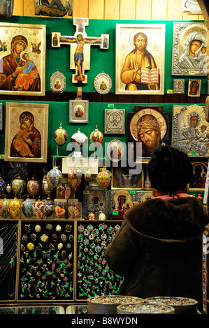 Femme vendant souvenirs tableaux religieux icônes articles shop stall à l'intérieur de la Halle aux draps Sukiennice intérieur Drapers' Hall Cracovie Banque D'Images