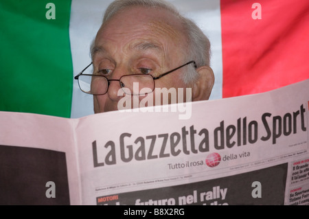 L'homme italien Senior sports lecture papier - drapeau national italien en arrière-plan Banque D'Images