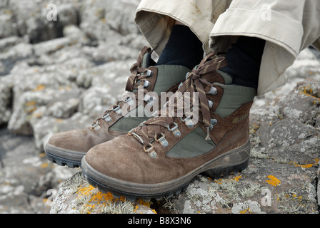 Les chaussures de marche d'un randonneur se hisse dessus sur un sentier rocheux sur un sentier Banque D'Images