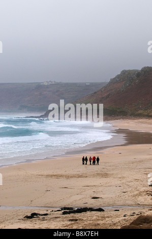 Les gens qui marchent sur la plage de Sennen à Cornwall le un jour brumeux. Banque D'Images