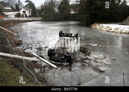 Panne de voiture et renversée en étang gelé UK Banque D'Images