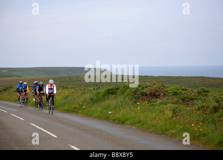 Les cyclistes masculins sur une route côtière de Cornwall Lands End à John O'Groats à longue distance Fin Cycle Ride England UK Banque D'Images