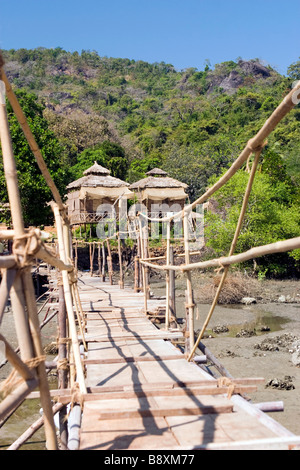 Passerelle au-dessus de la suspension en bambou avec des cabanons et rivière montagne sur arrière-plan. Banque D'Images