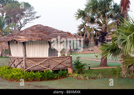 Bungalow isolé dans un parc entouré de palmiers tropicaux. Banque D'Images