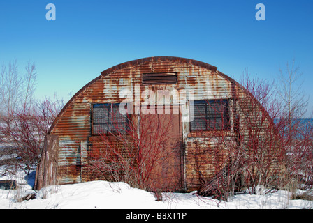 Un vieux déserté le métal hutte quonset entouré par des mauvaises herbes et des arbustes sur le Leslie Spit à Toronto Banque D'Images