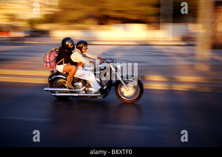 Un couple de personnes la moto en Sardaigne à la vitesse que les couchers de créer un flou Banque D'Images