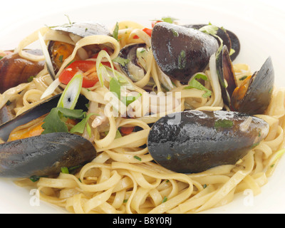 Les moules épicées fraîchement préparé avec des nouilles et des piments isolé sur un fond blanc avec aucun peuple et un chemin de détourage Banque D'Images