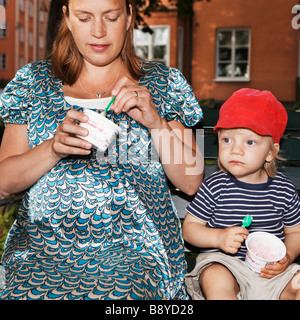 Une femme enceinte et un garçon la consommation de crème glacée de la Suède. Banque D'Images