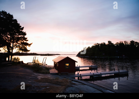 Un garage à bateaux au coucher du soleil dans l'archipel de Stockholm en Suède. Banque D'Images