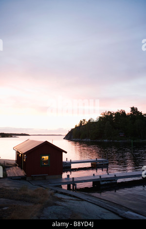 Un garage à bateaux au coucher du soleil dans l'archipel de Stockholm en Suède. Banque D'Images