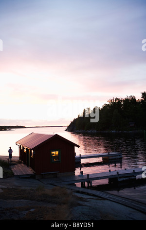 Un garage à bateaux au coucher du soleil dans l'archipel de Stockholm en Suède. Banque D'Images