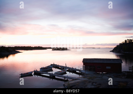 Un garage à bateaux au coucher du soleil dans l'archipel de Stockholm en Suède. Banque D'Images