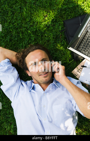 Un homme d'affaires avec un téléphone cellulaire dans un parc de la Suède. Banque D'Images