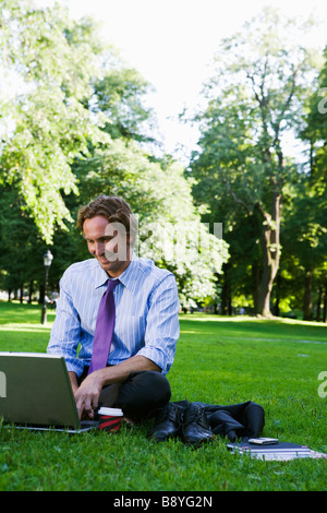 Un homme avec un ordinateur portable dans un parc de la Suède. Banque D'Images