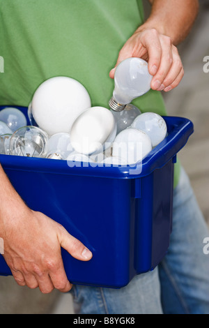 Un homme tenant ampoules pour le recyclage. Banque D'Images