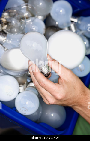 Un homme tenant ampoules pour le recyclage. Banque D'Images