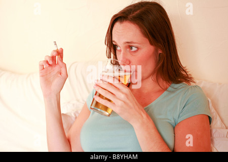 Femme enceinte de boire pinte de bière en verre d'alcool et plus de cigarettes Fumer nuit à foetus baby smiling mauvais régime health Banque D'Images