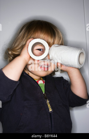 Une fille jouant avec des rouleaux de papier de la Suède. Banque D'Images