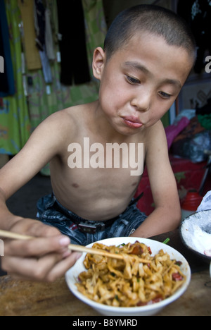 Kid chinois eating noodles, Pingyao, dans la province du Shaanxi, Chine Banque D'Images