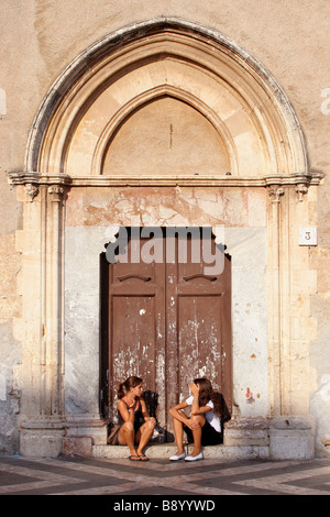 2 Filles assis dans une église porte dans la Piazza IX Aprile Taormina Sicile Banque D'Images