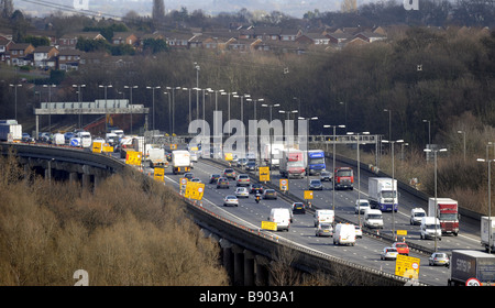 Une section surélevée de l'autoroute M6 À PROXIMITÉ DE BIRMINGHAM UK avec des maisons résidentielles à proximité. Banque D'Images