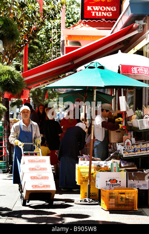 Les travailleurs chinois et les clients à faire leurs achats à l'extérieur sur la rue-de-Fisgard dans le quartier chinois de Victoria en Colombie-Britannique, Canada. Banque D'Images