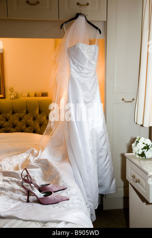 Jour de mariage, robe de la Mariée avec les chaussures et bouquet hanging dans la chambre avant de cérémonie Banque D'Images