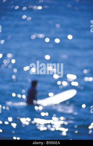 Surfer assis sur d'administration en attente d'une vague Banque D'Images