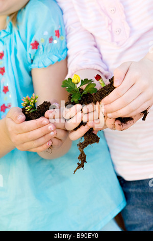 Deux jeunes filles tenant des fleurs. Banque D'Images