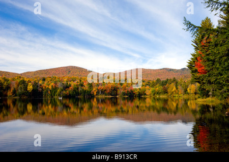 Un lac calme avec reflets et couleurs des feuilles d'automne en milieu rural Vermont USA Banque D'Images