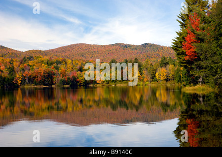 Un lac calme avec reflets et couleurs des feuilles d'automne en milieu rural Vermont USA Banque D'Images