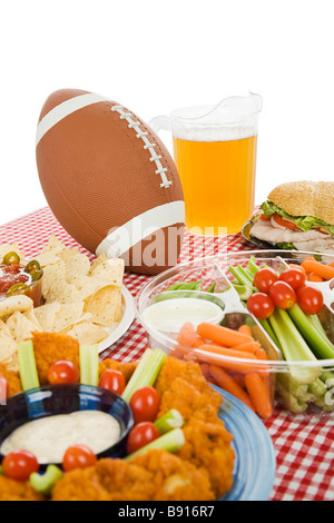 Set de table avec des casse-croûte pour un Super Bowl party focus sur le football vue verticale avec fond blanc Banque D'Images