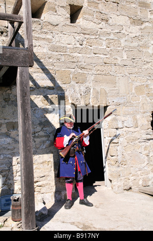 Richard Shortlidge vêtu comme un soldat espagnol dans les années 1740 vérifie son mousquet au Fort Matanzas National Monument Banque D'Images