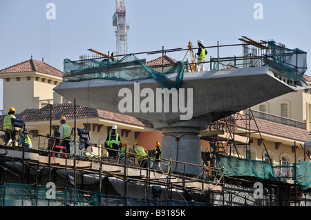 Travailleurs sur le chantier de construction du métro de Dubaï sur béton frais bridges & viaducs travaillant dans des casques de sécurité et de haute visibilité Vestes Émirats arabes Unis Banque D'Images