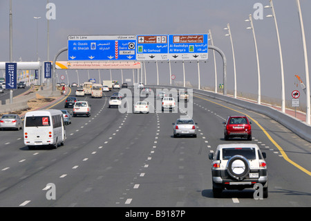 Voitures et circulation à Dubaï le long des autoroutes à sept voies et panneaux bleus du statif menant aux terminaux 1 et 3 de l'aéroport Emirats Arabes Unis Émirats Arabes Unis Moyen-Orient Banque D'Images