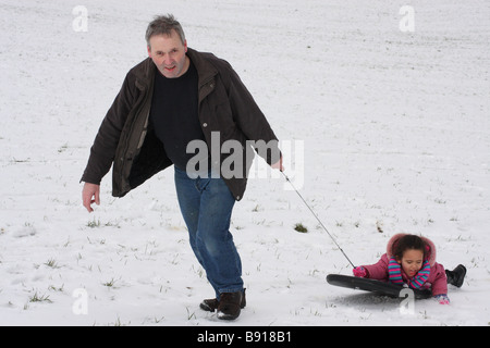 Père blanc fille fille toddlerl ethnique noir mixed race happy smiling amusement jouer jeune glace neige snowboard Banque D'Images