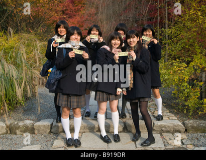 Filles de l'école de japonais détiennent leurs billets d'entrée au jardin zen de Ryoanji Japon Kyoto Banque D'Images