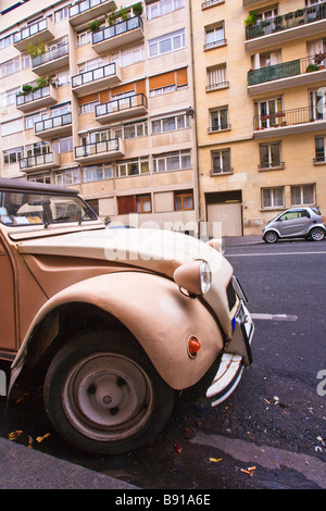 Vieille 2 cv Citroën stationné dans la région de Paris, France. Sur le côté opposé de la route est en stationnement smart. Banque D'Images