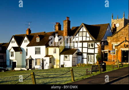 Tôt le matin, la lumière tombe sur les maisons sur le vert de l'anglais typique bourg de Marlborough Wiltshire England UK Banque D'Images