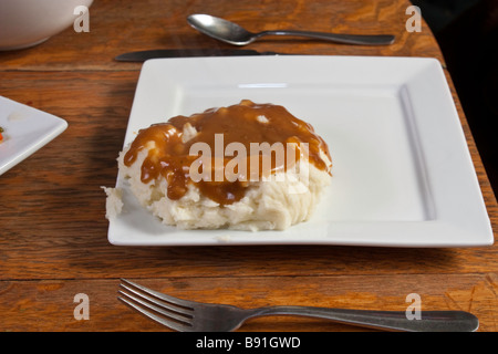 Purée de pommes de terre et de la sauce sur une assiette blanche Banque D'Images