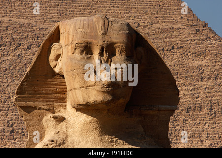 'Close up' de face avant Grand Sphinx tête, pyramide de Khafré en arrière-plan, Giza, Le Caire, Egypte Banque D'Images