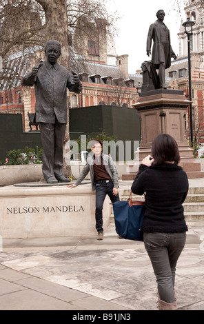 Oriental asiatique couple de touristes dans 20s / 30s visite à Londres ; les statues de Nelson Mandela et de Robert Peel Banque D'Images
