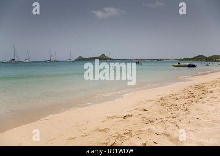 La plage de Reduit avec l'île Pigeon au loin, St Lucia. Banque D'Images