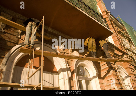 La réparation des accidents sur des échafaudages de façade en briques rouges, Ekaterinbourg, Oural, Russie Banque D'Images
