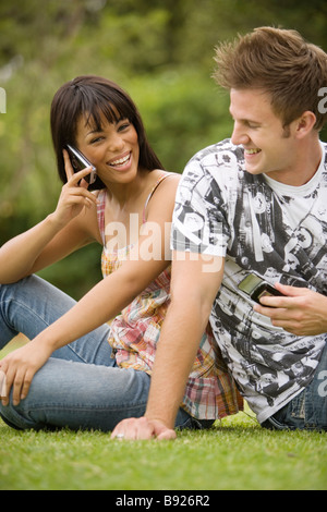 La culture de l'adolescence de l'Afrique du Sud jeune couple assis dos à dos sur l'herbe Banque D'Images
